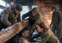“Lift the beam or he dies right now!” I screamed as fire consumed the cabin. I was just a prisoner, but watching the scarred sergeant pinned under heavy timber while a beautiful nurse wept for his life made me choose humanity over my only chance at freedom.